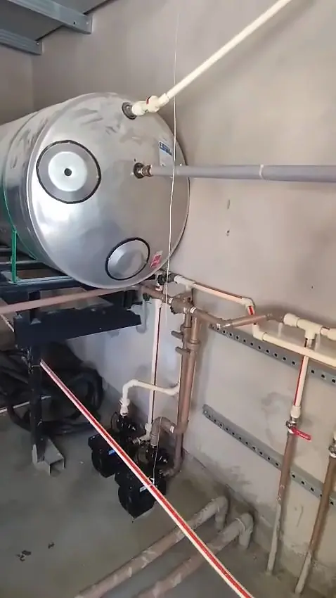 Casa de máquinas com boiler de inox e conjunto de bombas ligado por tubulação de cobre e CPVC
