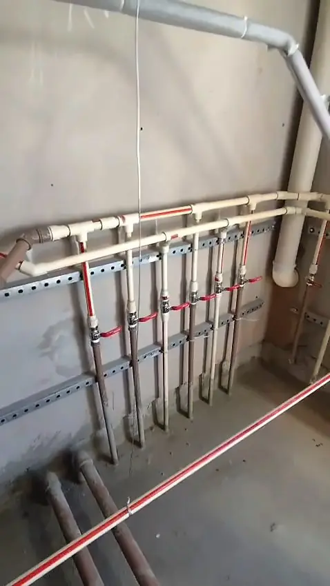 Barrilete com registros e tubulação de CPVC fixada em suporte metálico na parede de uma casa de máquinas
